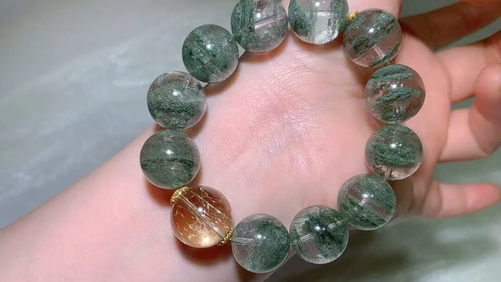 Green Phantom Quartz Bracelet 16.3mm with large clear beads full of moss-green phantoms and a peach-amber toned accent bead