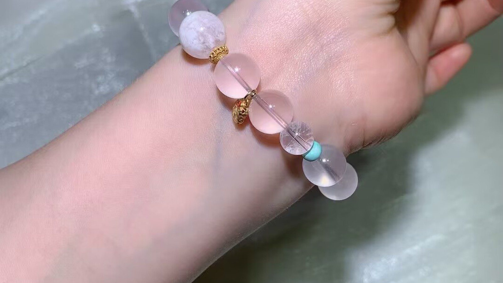 Star rose quartz bead bracelet with a sky-blue accent worn on a wrist