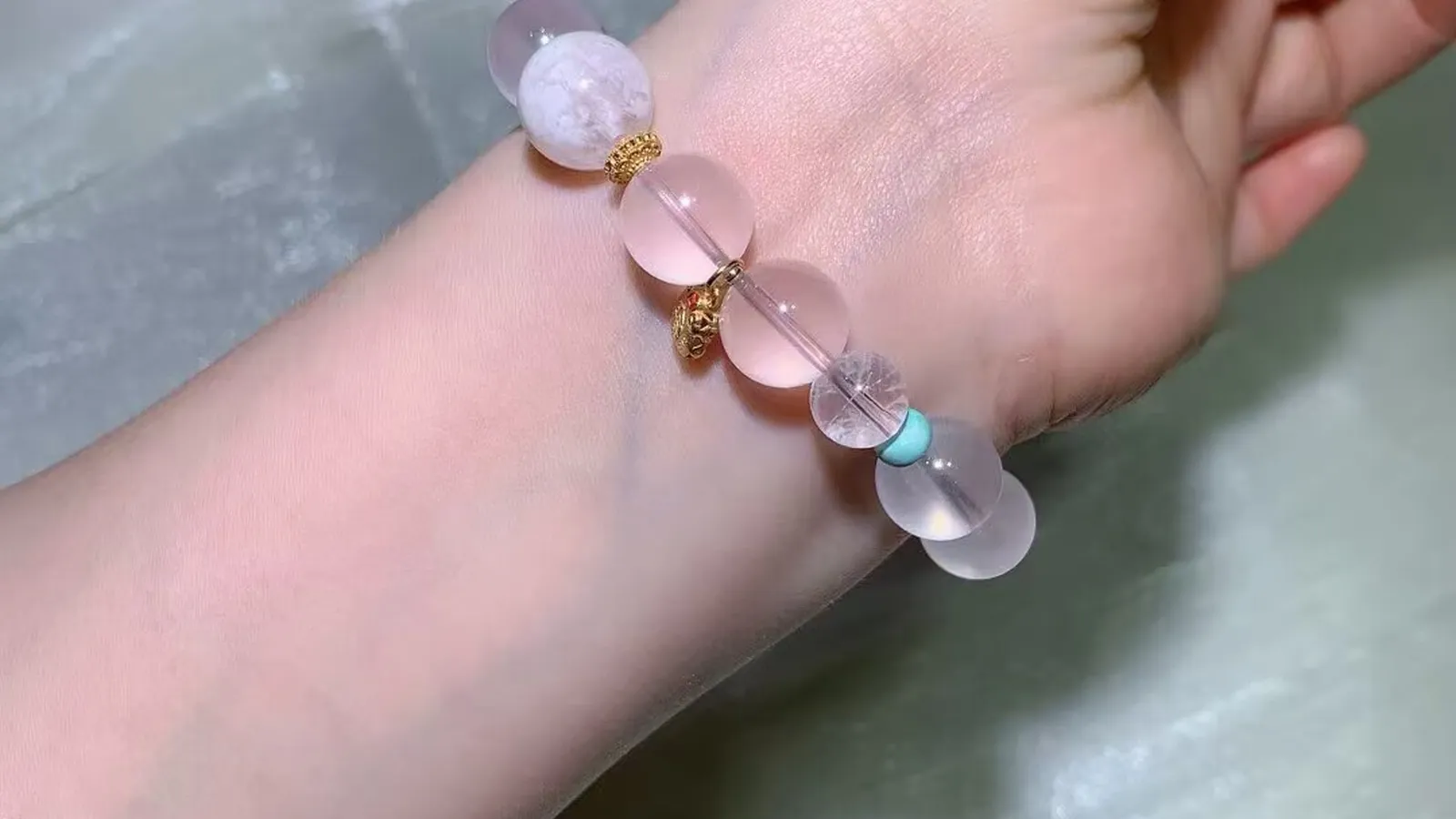 Star rose quartz bead bracelet with a sky-blue accent worn on a wrist