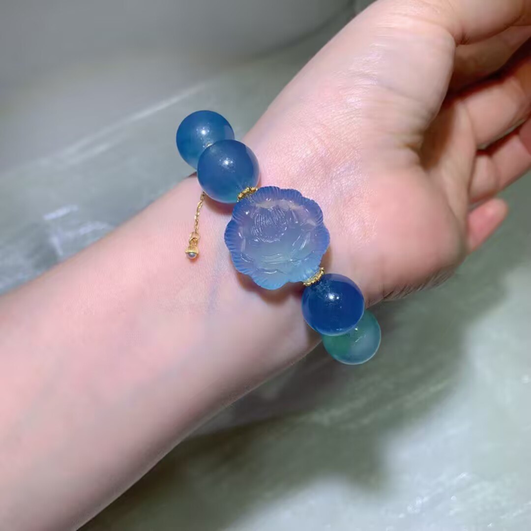 Deep glacier-blue aquamarine beads with a carved aquamarine flower and a pale pink quartz bead