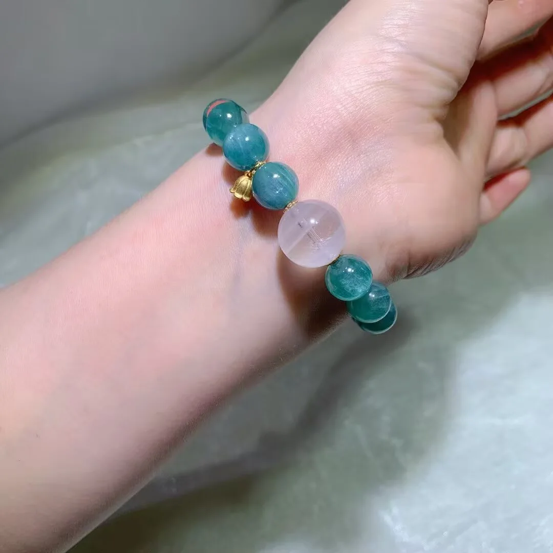 Blue-green crystal bracelet detail with pink-white and coral-red accent beads