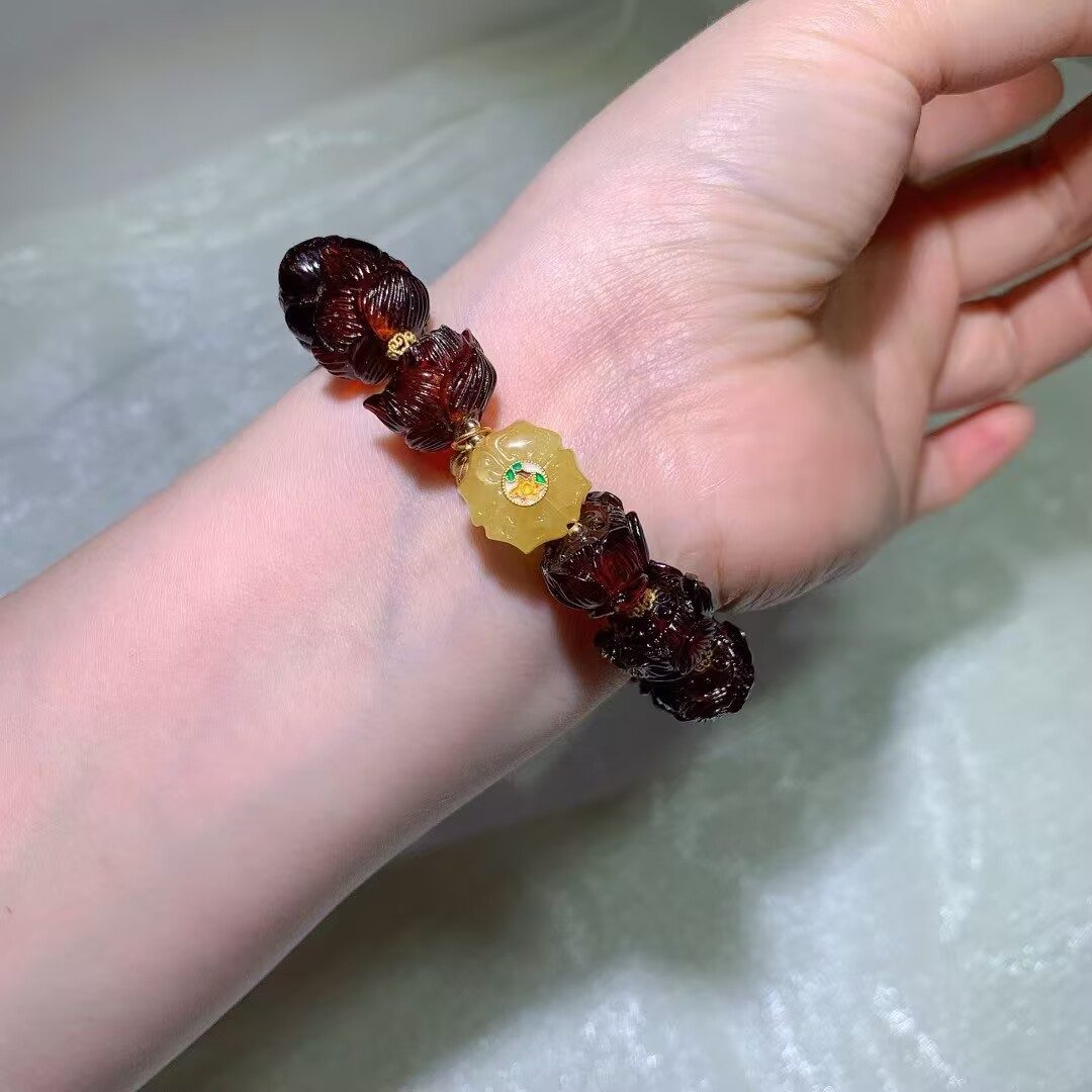 Detail of hand-carved Blood Amber lotus beads, best cared for with a soft, dry cloth
