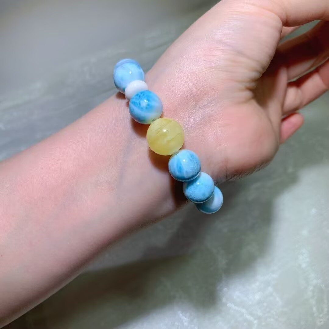 Detail of natural larimar beads with irregular white web patterns on sky-blue