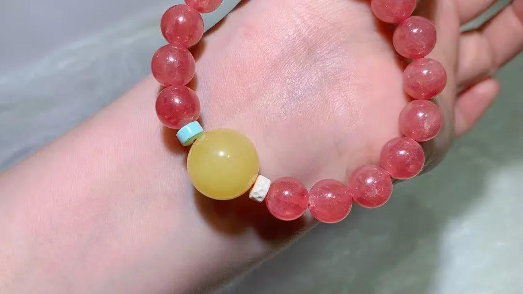 Rhodochrosite bracelet with rose-red beads and one large honey amber bead