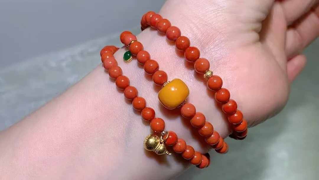 Southern red agate multi-wrap bracelet in warm persimmon red with a honey-yellow beeswax barrel bead and a vintage-style gourd charm